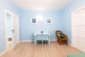 ソポトにあるVictus Apartamenty, Apartament Romaの青い壁のダイニングルーム(テーブル、椅子付)