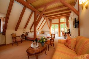 a living room with a couch and a bed and a table at Landhotel der Schafhof Amorbach in Amorbach