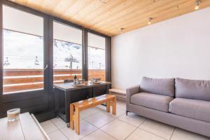 - un salon avec un canapé et une table dans l'établissement Résidence Le Borsat - Tignes Val Claret, à Tignes