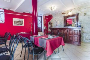 a dining room with red walls and a table with chairs at Palace Derossi in Trogir