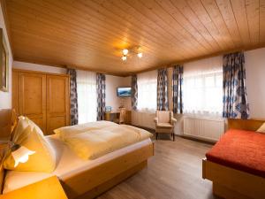 sypialnia z łóżkiem i krzesłem w obiekcie Apartments Quehenberger w mieście Maishofen +26 zdjęć