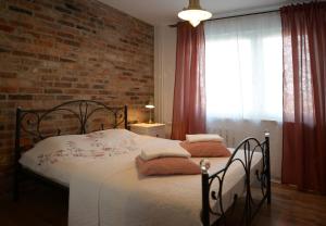 ソスノヴィエツにあるApartamenty Europaのレンガの壁、ベッド付きのベッドルーム1室