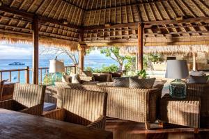 a living room with couches and a table and chairs at Villa Sayang in Nusa Lembongan