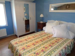 a bedroom with a bed with a colorful blanket and pillows at La Ferme de Germain in Lagorce +20 photos