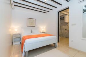 1 dormitorio con 1 cama con manta naranja en Apartment Ribica en Slatine