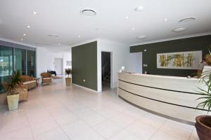 a lobby with a waiting area with plants in it at The Coast Motel in Yeppoon