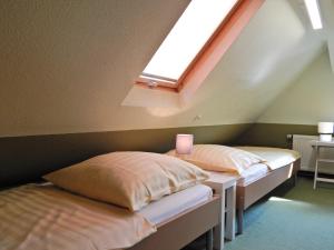 2 Betten in einem Dachzimmer mit Dachfenster in der Unterkunft Haus des Handwerkers in Koblenz