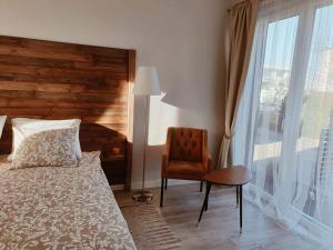 sypialnia z łóżkiem, krzesłem i oknem w obiekcie Apartament Natura I we Władysławowie