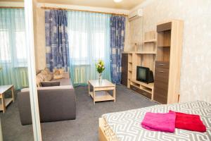ザポリージャにあるSemi-luxury Apt on 82 Nezalezhnoi Ukrаiny Street near Intourist Hotelのベッドルーム(ベッド1台、ソファ、テレビ付)
