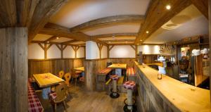 restauracja z drewnianymi ścianami oraz drewnianymi stołami i krzesłami w obiekcie Apartments Quehenberger w mieście Maishofen