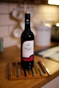 una botella de vino sentada en una mesa de madera en Gogarth hall Farm holidays, en Pennal