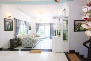 ein Wohnzimmer mit einem Sofa und einem Stuhl in der Unterkunft Palm Villa 19 in Vũng Tàu