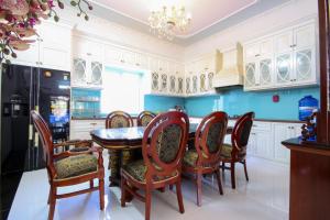 eine Küche mit einem Tisch und Stühlen sowie blauen Wänden in der Unterkunft Palm Villa 19 in Vũng Tàu