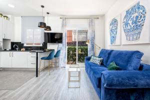 sala de estar con sofá azul y cocina en iloftmalaga Moreno Carbonero, en Málaga