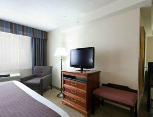 a hotel room with a bed and a flat screen tv at Holiday Inn Hinton, an IHG Hotel in Hinton
