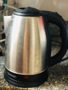 uma chaleira de prata e chá preto no balcão em Snow Pearl Homestay Hoi An em Hoi An