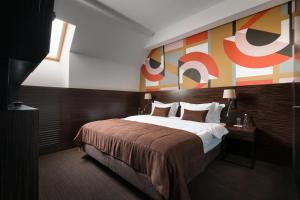 リヴィウにあるBANKHOTELのベッド付きの客室で、壁には絵画が飾られています。