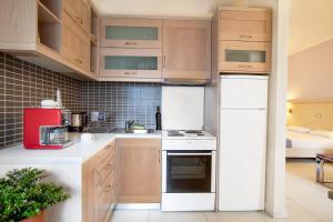a kitchen with wooden cabinets and white appliances at Giorgi's Blue Apartments in Kalathas