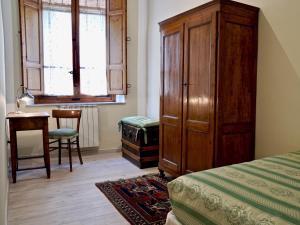 a bedroom with a large wooden cabinet and a bed at Palazzo Colombini Apartment in Lucca