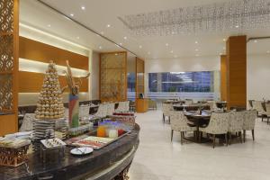 a dining room with tables and chairs in a restaurant at Nataraj Sarovar Portico in Jhānsi