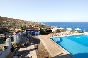 a view of a swimming pool and the ocean at Giorgi's Blue Apartments in Kalathas