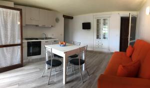 a kitchen and living room with a table and chairs at Sardegna Beach Cala Reale in Santa Marinella