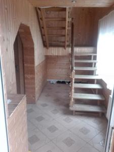 a room with a staircase in a building at На Беріжку in Mykulychyn