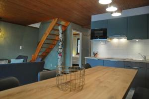 a kitchen with a wooden table and a spiral staircase at Maison du Lac Vielsalm in Vielsalm