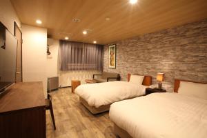 a hotel room with two beds and a brick wall at Sundance Resort Karuizawa in Karuizawa