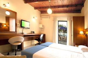 a bedroom with a bed and a desk with a computer at Giorgi's Blue Apartments in Kalathas