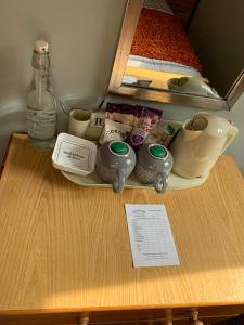 a wooden table with a shelf with a bottle and dishes at Greenacre in Oban