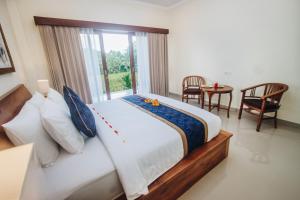 
a hotel room with two beds and a table at Kapu Kapu Ubud in Ubud
