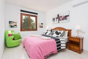 a bedroom with a bed and a green chair at Ropit in Port d'Alcudia +21 photos