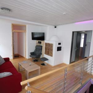 ein Wohnzimmer mit einem roten Sofa und einem Stuhl in der Unterkunft Ferienwohnung Stiftstadt Kempten in Kempten