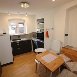 ein Wohnzimmer mit einem Tisch und einer Küche in der Unterkunft Ferienwohnung Stiftstadt Kempten in Kempten