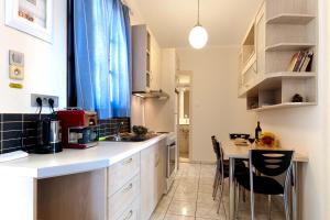 a kitchen with a counter and a table with chairs at Giorgi's Blue Apartments in Kalathas