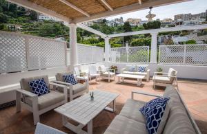 eine Terrasse mit Sofas, Stühlen und einem Tisch in der Unterkunft Villa Patrizi in Capri