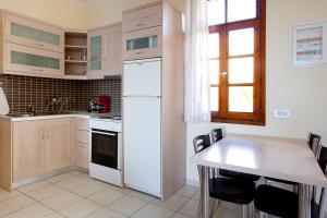 a kitchen with a white refrigerator and a table at Giorgi's Blue Apartments in Kalathas