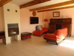 a living room with red chairs and a fireplace at La Ferme de Germain in Lagorce