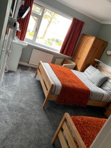 een slaapkamer met 2 bedden en een raam bij Greenacre in Oban