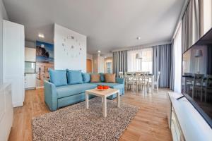 コウォブジェクにあるApartamenty Sun & Snow Wyspa Solnaのリビングルーム(青いソファ、テーブル付)