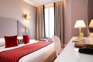 a hotel room with a bed and a desk at Hôtel Victor Hugo Paris Kléber in Paris +33 photos
