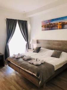 1 dormitorio con 1 cama grande y toallas. en Napoli Suites, en San Julián