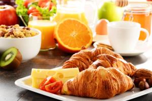 a plate of food with croissants and other breakfast foods at B&B Lo&G in Lascari