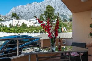 un tavolo con un vaso di fiori su un balcone di Apartman Barbara a Makarska
