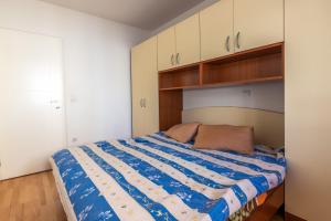 una camera da letto con un letto con un piumone blu e bianco di Apartman Barbara a Makarska