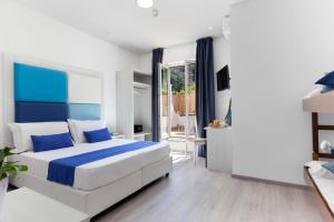 a white and blue bedroom with a large bed at Eden Bleu in Vico Equense
