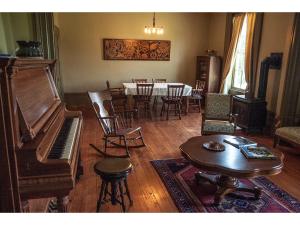 a living room with a piano and a table and chairs at Culverdene House in Simcoe