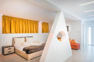 a white bedroom with a bed and yellow curtains at Fior Apartments Lofts in Merano