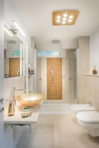 La salle de bains est pourvue d'un lavabo, de toilettes et d'une douche. dans l'établissement Fior Apartments Lofts, à Merano